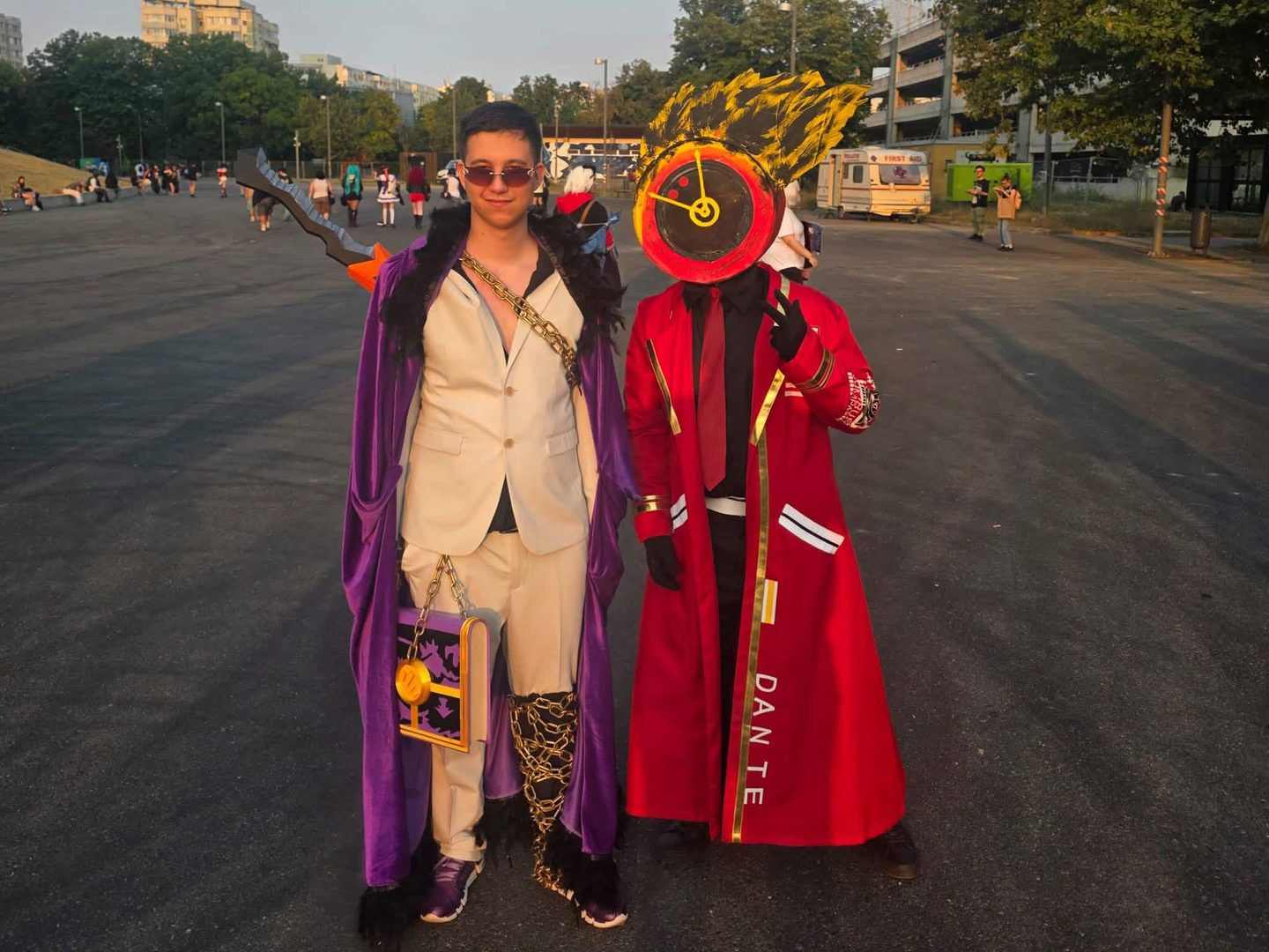 Alex in cosplay, a cream suit and purple fur-trimmed coat, next to someone dressed as Dante with a clock for a head